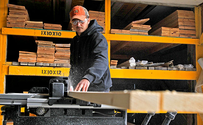 man cutting lumber